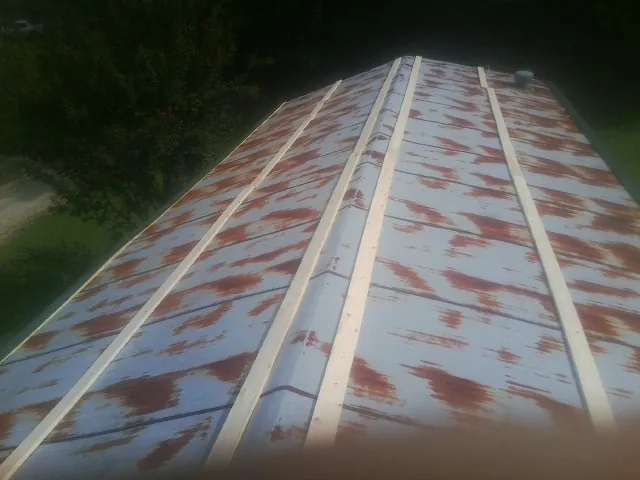 Rusted metal roof panels with new wood purlins before replacement — Storm Damage Roof Repair in Ballston Spa by Roofing Brothers